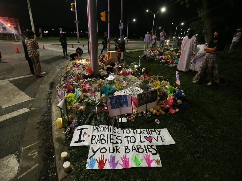 People leave flowers and light candles at the scene of what has been called an Islamophobic terrorist attack that killed four family members earlier this week.