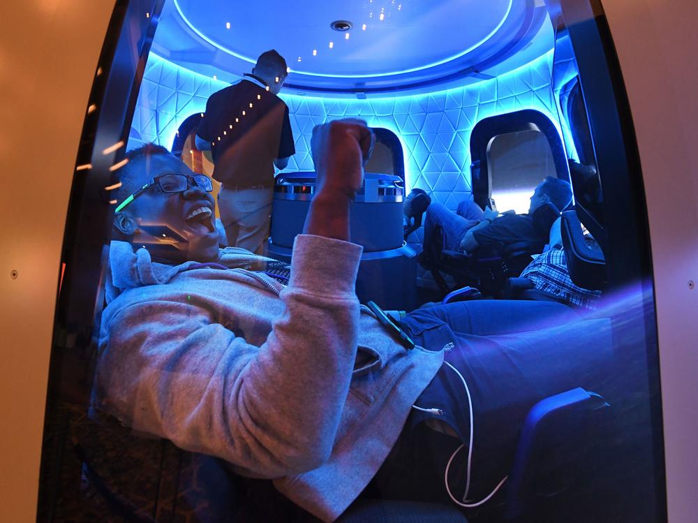 Participants sit a Blue Origin space simulator during a conference on robotics and artificial intelligence in Las Vegas on June 5, 2019. On Saturday, Blue Origin announced that an unidentified bidder will pay $28 million for a suborbital flight on the company's New Shepard vehicle.