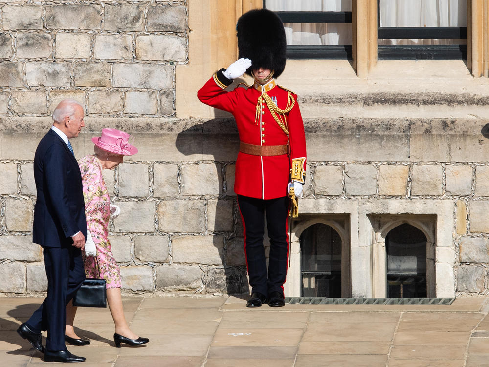 Queen Elizabeth II and President Biden walk at Windsor Castle on Sunday in Windsor, England. This is Biden's first private meeting with Queen Elizabeth II since becoming president.