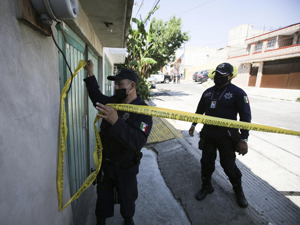Police mark a security perimeter around the house where bones were found under the floor in the Atizapan municipality of the State of Mexico, on May 20, 2021. Police have turned up bones and other evidence under the floor of the house where a man was arrested for allegedly stabbing a woman to death and hacking up her body.