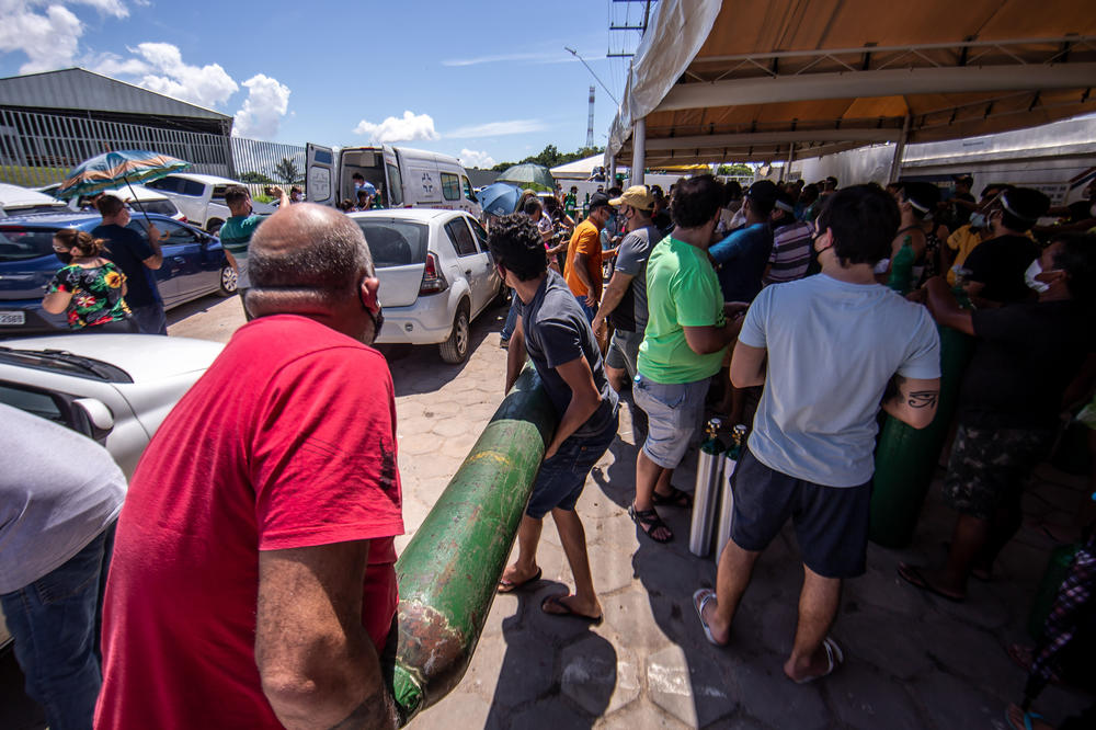 People wearing protective masks wait in line to refill oxygen bottles in January in Manaus, Brazil.