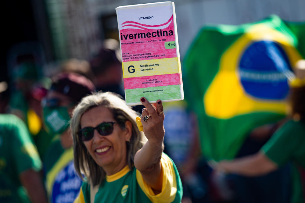At a May 15 rally in Brasilia, a Bolsonaro supporter holds up a large box of ivermectin. The anti-lice medication is one of the drugs promoted as early treatment by Bolsonaro's administration despite a lack of evidence for its effectiveness.