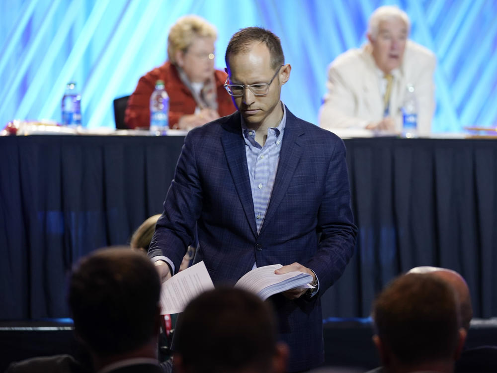 Jared Wellman, pastor at Tate Springs Baptist Church in Arlington, Texas, on Monday hands out copies of his motion that called for an independent committee to lead a probe of the denomination's handling of sex abuse cases.