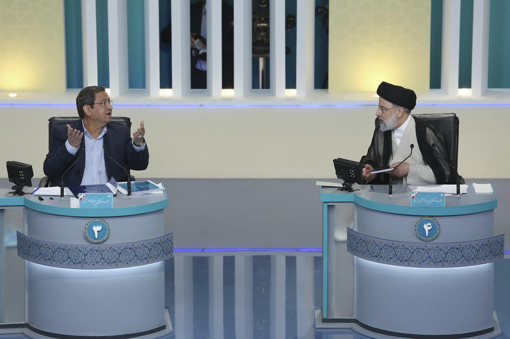 Iranian presidential candidate Abdolnasser Hemmati (left) speaks as Ebrahim Raisi listens in the candidates' final debate at a state-run TV studio in Tehran, Iran, on June 12.
