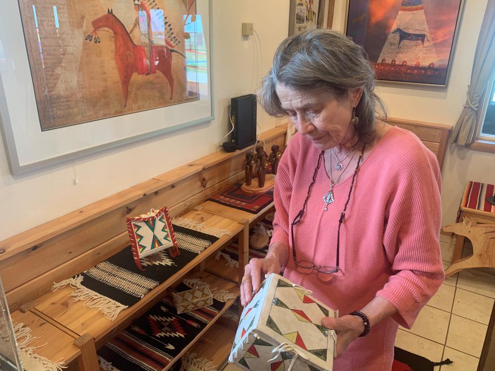 Angelika Harden-Norman holds a parfleche box made by her late husband, Darrell Norman. Harden-Norman made both traditional and modern Blackfeet artwork. Parfleche boxes are painted containers made from animal hide. They were used by Native Americans to carry items as they traveled.