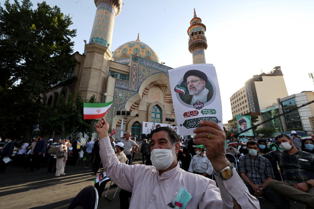 Supporters of Iranian ultraconservative presidential candidate Ebrahim Raisi carry posters bearing his portrait and wave national flags as they attend a rally in the capital Tehran, on Wednesday, ahead of the presidential election on Friday. The field of candidates in Iran's presidential election thinned today, two days before the vote in which a victory by Raisi is widely predicted.
