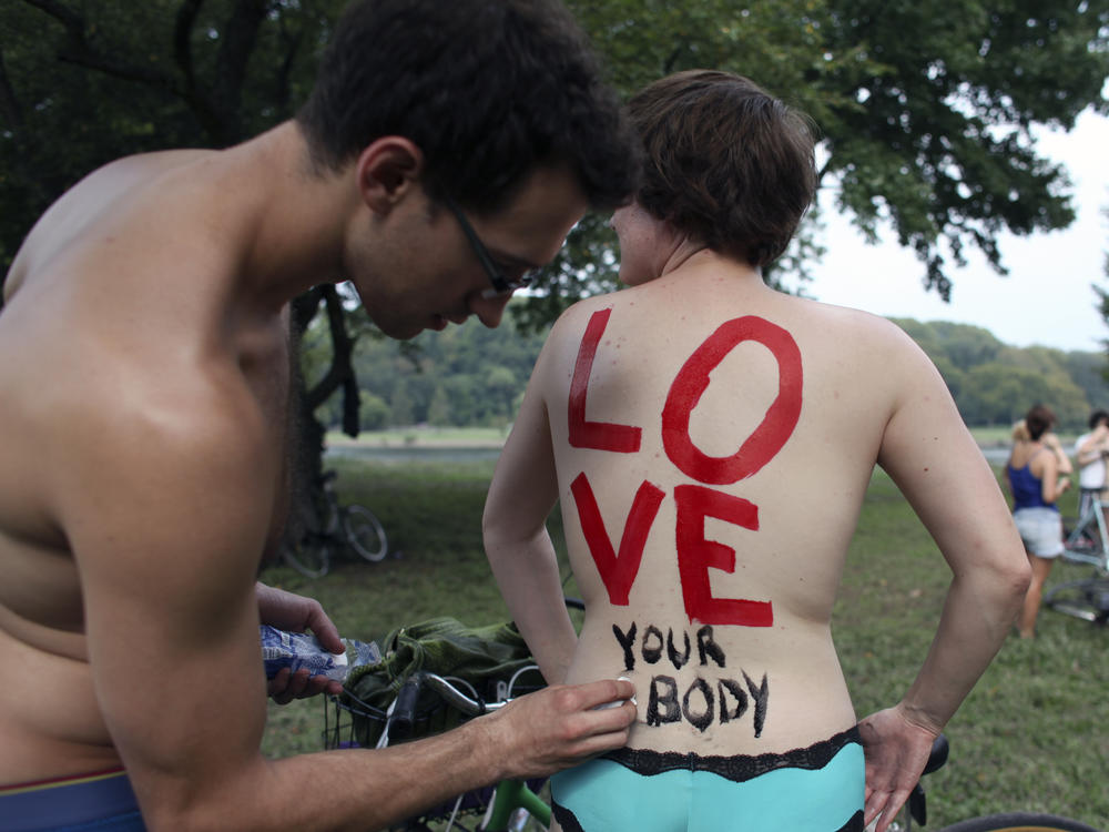 On Sunday, Sept. 4, 2011 Cheryl Rehmann has a message painted on her back by Matthew Wellstein before the start of the annual Naked Bike Ride in Philadelphia.