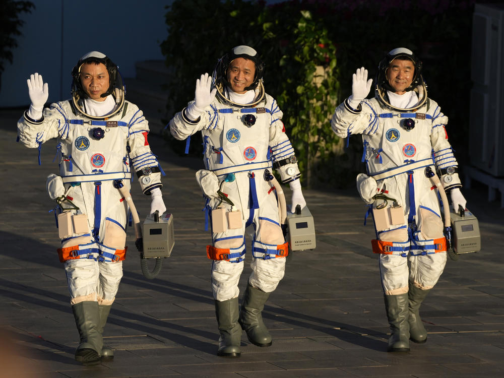 Chinese astronauts, from left, Tang Hongbo, Nie Haisheng, and Liu Boming wave as they prepare to board for liftoff Thursday at the Jiuquan Satellite Launch Center in Jiuquan in northwestern China. China plans to launch three astronauts onboard the Shenzhou-12 spaceship who will be the first crew members to live on China's new orbiting space station Tianhe, or Heavenly Harmony.