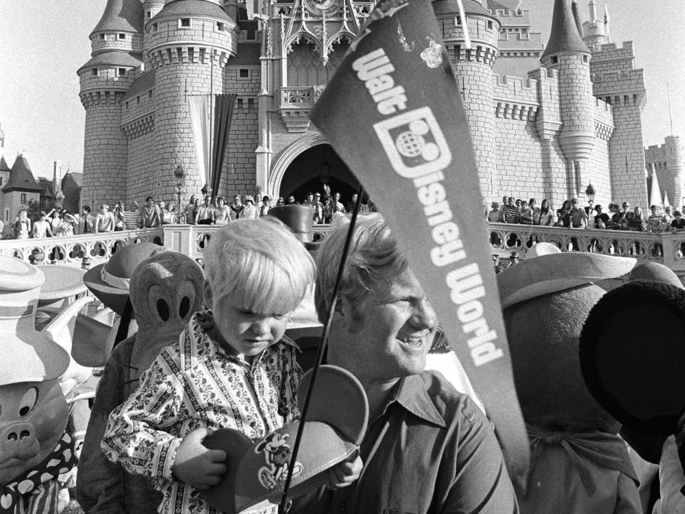 When Disney World opened on Oct. 1, 1971, tickets for adults were just $3.50. Here, William Windsor Jr. carries his son Lee, past Cinderella's castle on opening day.