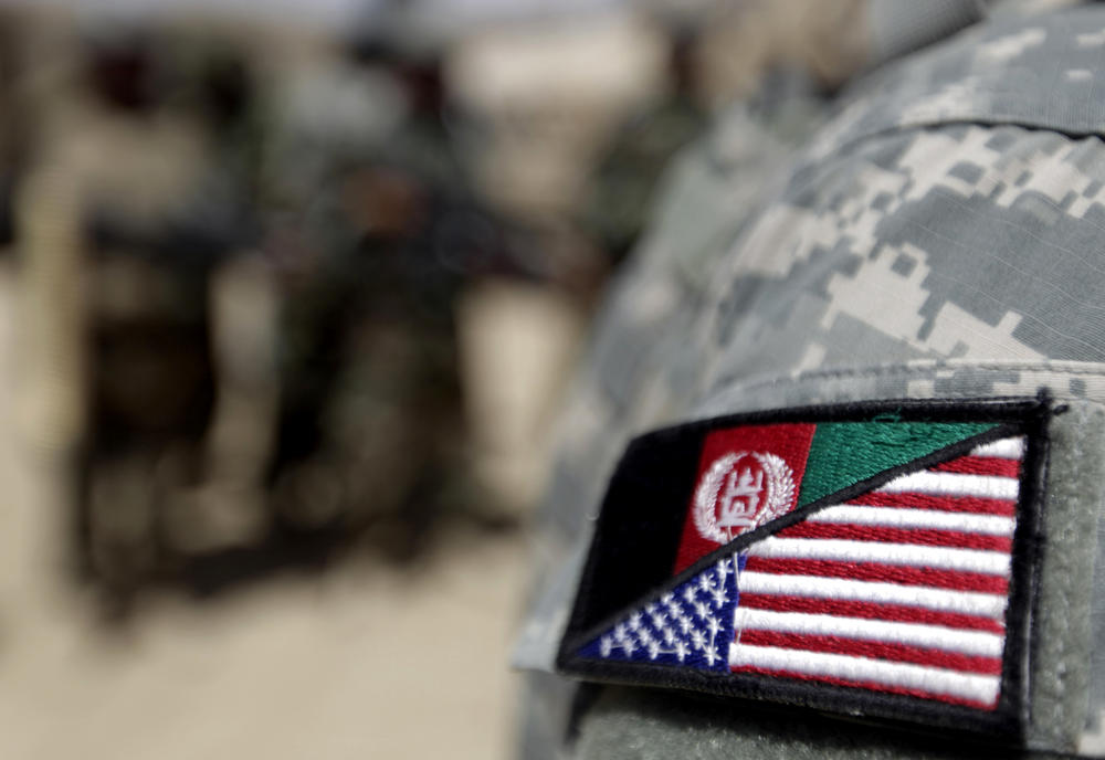 An Afghan interpreter working with the 101st Airborne Division  displays a patch showing the Afghan and U.S. flags.