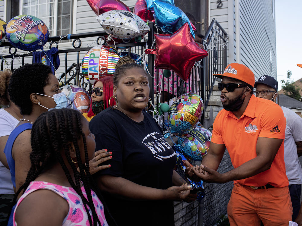 Shanduke McPhatter, a non-violence activist, talks to a woman who recently lost a relative to gun violence. The peace vigil took place on the block where 10-year-old Justin Wallace was shot to death.