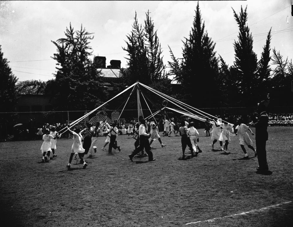 Children dancing around a maypole.