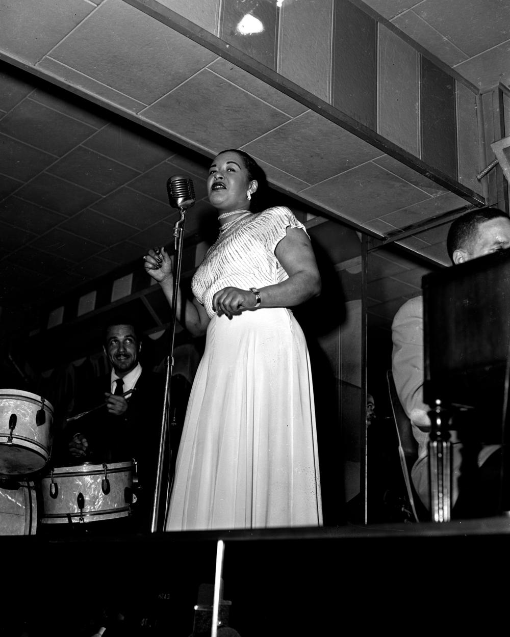 Billie Holiday singing with a band.