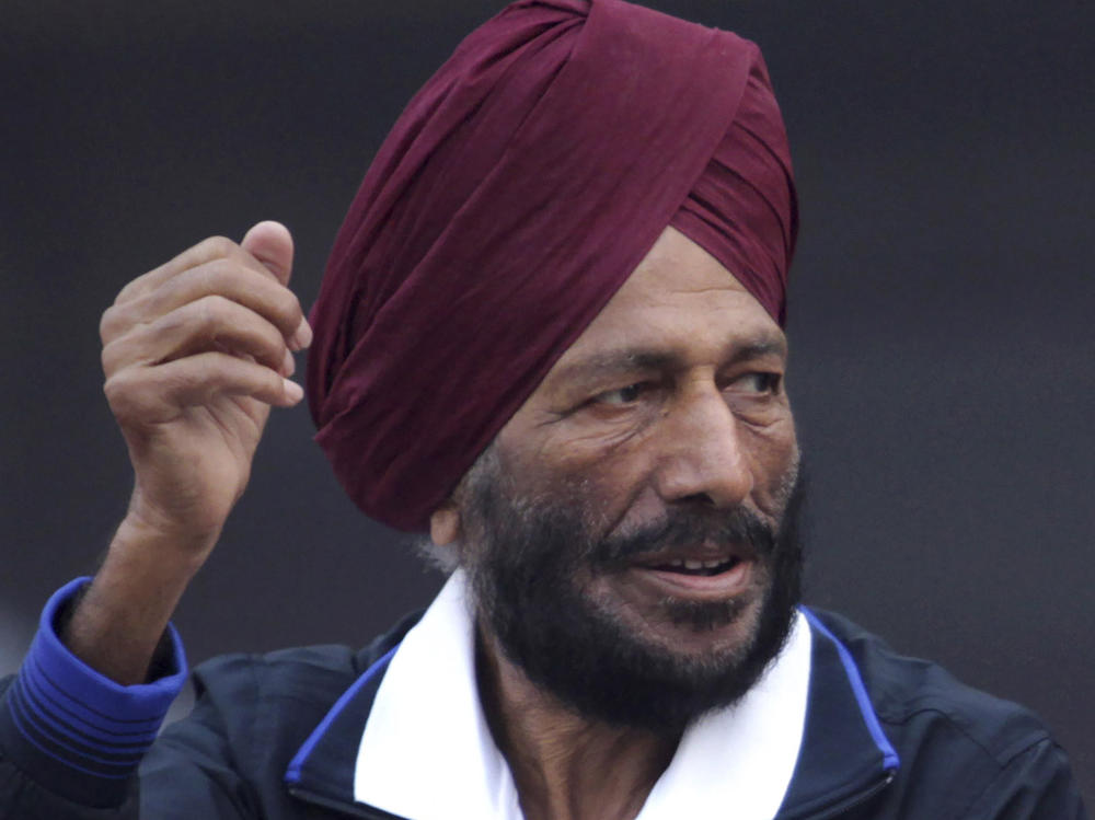 In this Dec. 15, 2013, file photo, former Indian athlete Milkha Singh, with, and Bollywood actor Bipasha Basu waves to the participants during the Delhi Half Marathon in New Delhi, India.