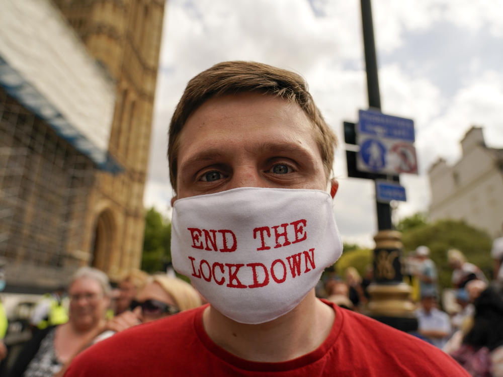 A man wears a mask reading 