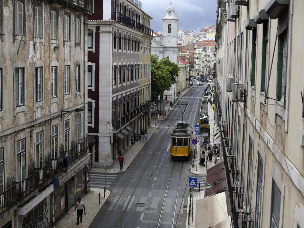 A tram drives through an empty downtown Lisbon, Portugal, on Friday. Portuguese<em> </em>authorities banned all weekend travel in and out of the capital to cut down on any further spread of the coronavirus to other parts of the country.