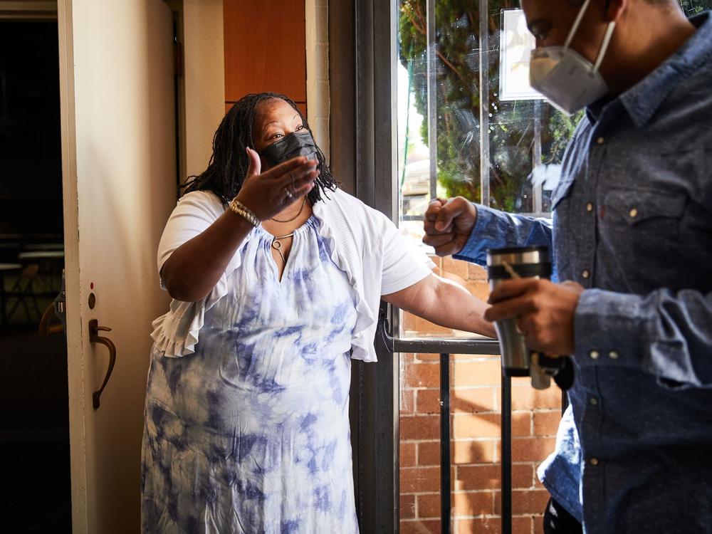 Community health worker Teresa Johnson greets Pastor Shon Neyland before Sunday church services. Highland Christian Church estimates about half of its congregation is still not vaccinated.