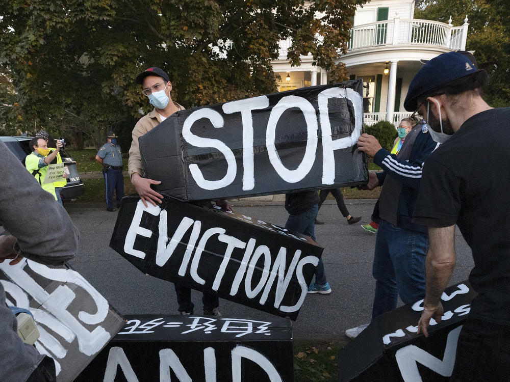 Housing activists erect a sign in front of Massachusetts Gov. Charlie Baker's house in Swampscott, Mass., on Oct. 14, 2020. The Centers for Disease Control and Prevention has extended a moratorium on evictions until the end of July.