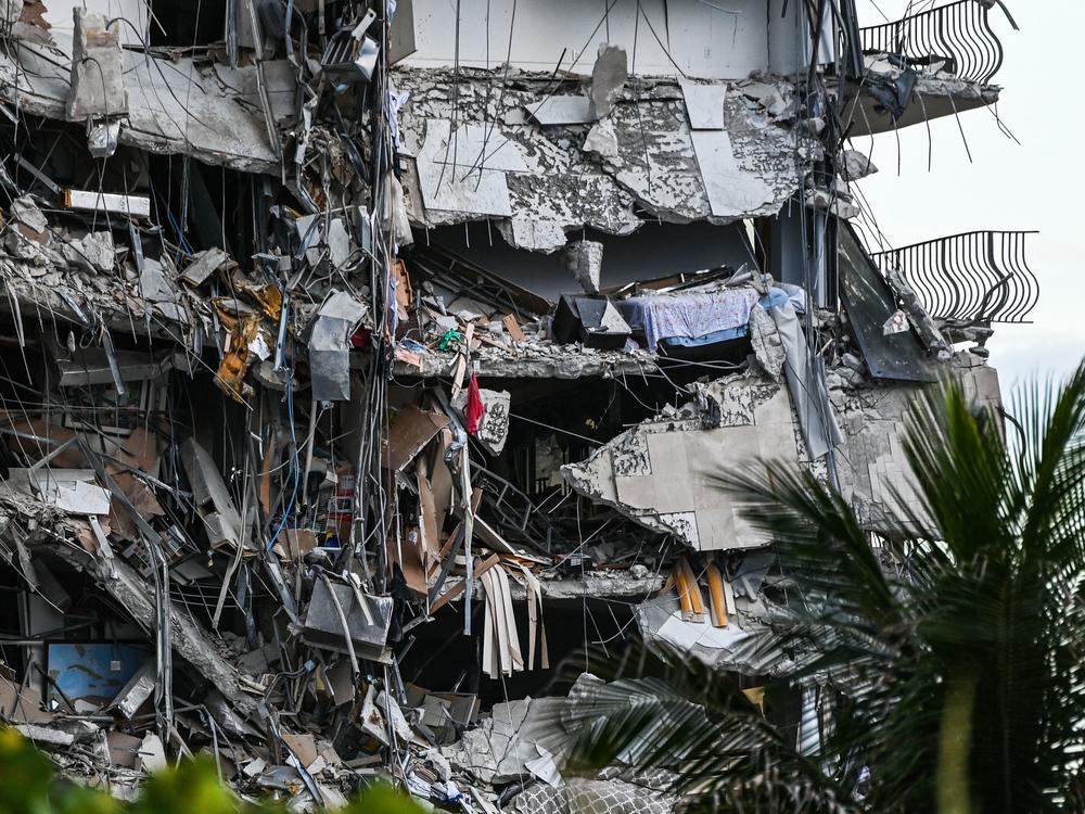Rubble hangs from the partially collapsed building in Surfside, Fla., on Thursday. The multistory apartment block north of Miami Beach partially collapsed early Thursday morning, sparking a major emergency response.