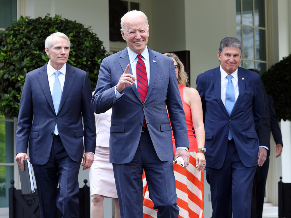 President Biden, joined by a group of senators, gets ready to deliver remarks Thursday at the White House after reaching a bipartisan deal on an infrastructure package.