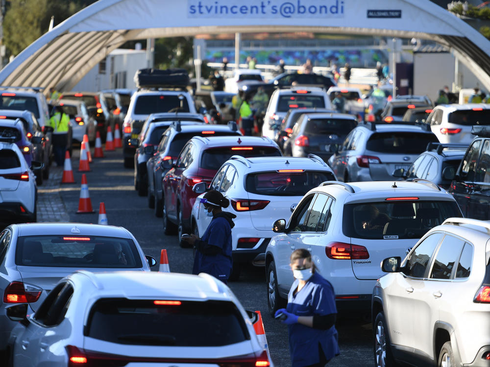 People line up in their cars to get tested for COVID-19 at a pop-up testing clinic at Bondi Beach in Sydney on Friday. Parts of Sydney will go into lockdown late Friday because of a growing coronavirus outbreak in Australia's largest city.