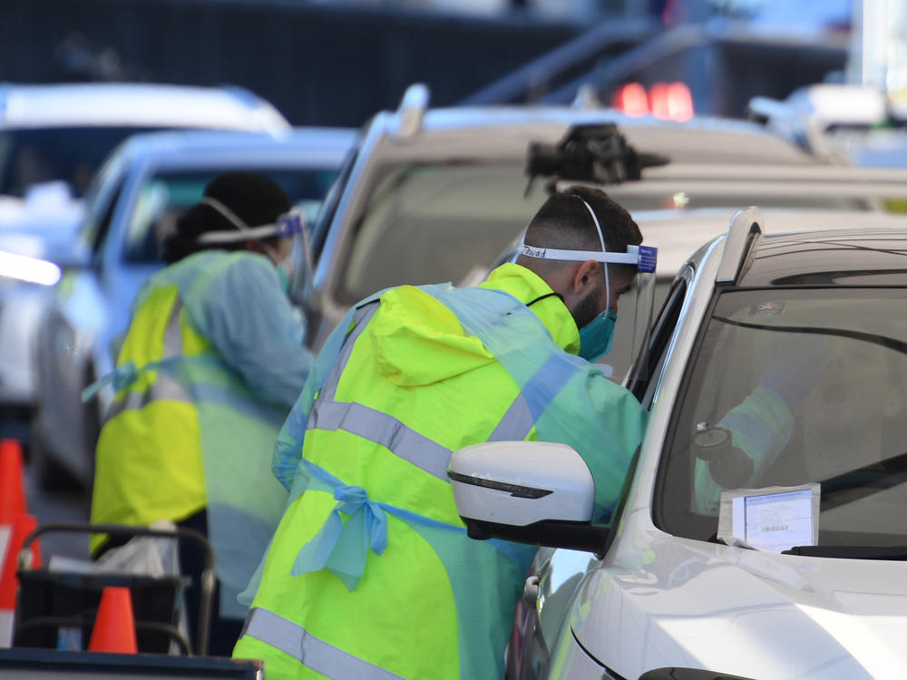 People line up in their cars to get tested for COVID-19 at a pop-up testing clinic at Bondi Beach in Sydney on Friday. Parts of Sydney will go into lockdown late Friday after a coronavirus outbreak in Australia's largest city continued to grow.