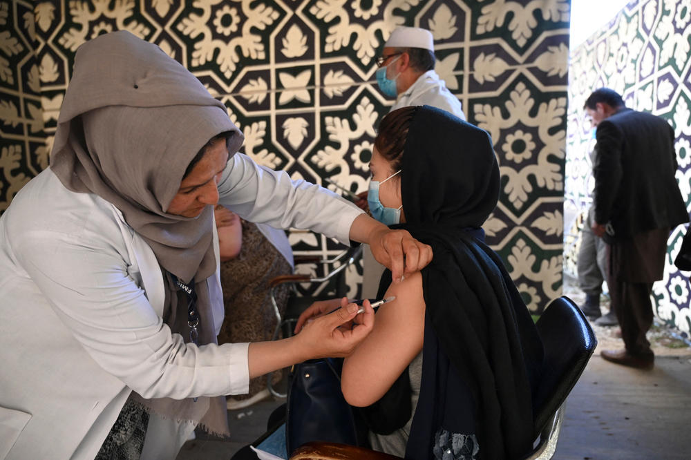 A health worker inoculates a woman with a dose of the Covishield vaccine, manufactured in India, at a vaccination center in Kabul.