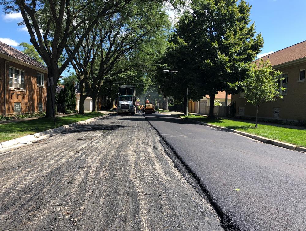 A road works crew repaves a street in a Chicago neighborhood.