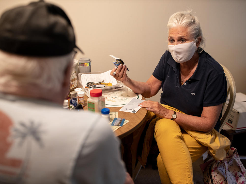 Kathleen McAuliffe, a home care worker for Catholic Charities in a Portland, Maine, suburb, helps client John Gardner with his weekly chores. McAuliffe shops for Gardner's groceries, cleans his home and runs errands for him during her weekly visit.