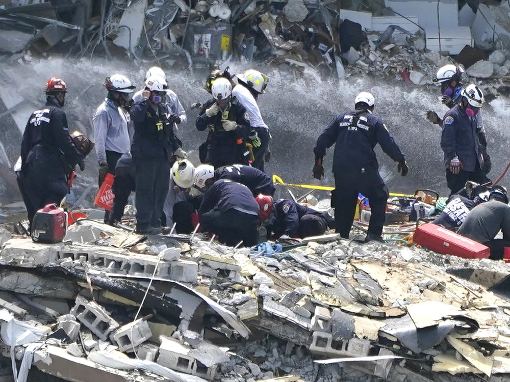 Rescue workers search the rubble of the Champlain Towers South condominium on Saturday in the Surfside area of Miami. The building partially collapsed on Thursday.