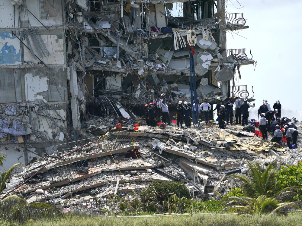 Rescue workers search in the rubble Saturday at the Champlain Towers South condominium in Surfside, Fla. The building partially collapsed on Thursday.