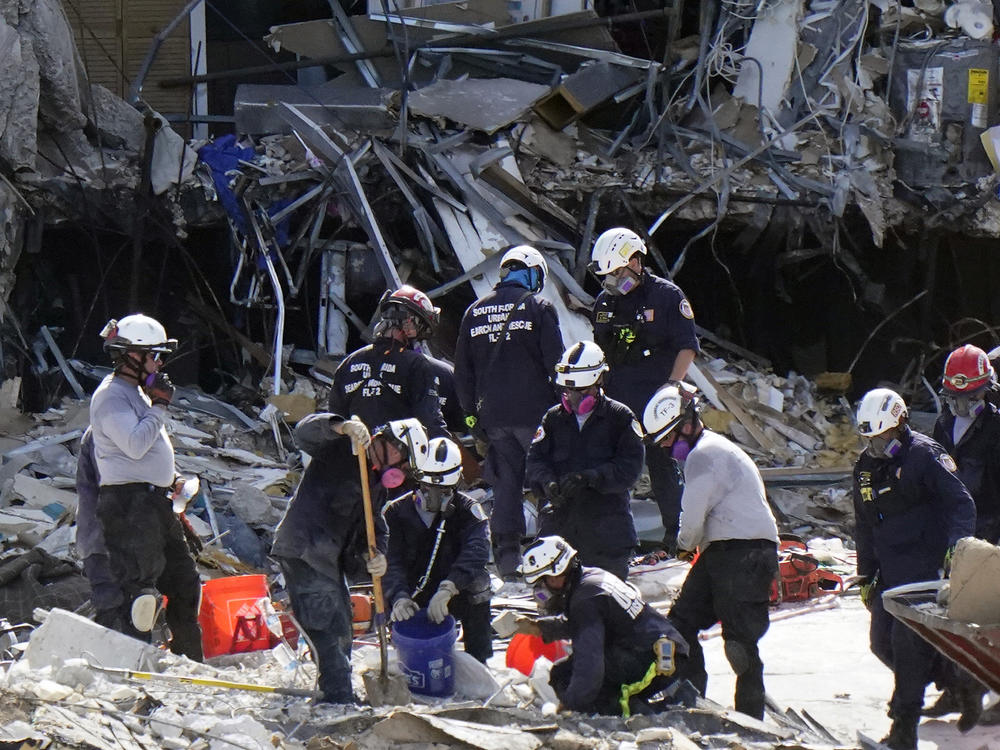 Crews work in the rubble at the Champlain Towers South condo on Sunday in Surfside, Fla. Many people are still unaccounted for after Thursday's fatal collapse.