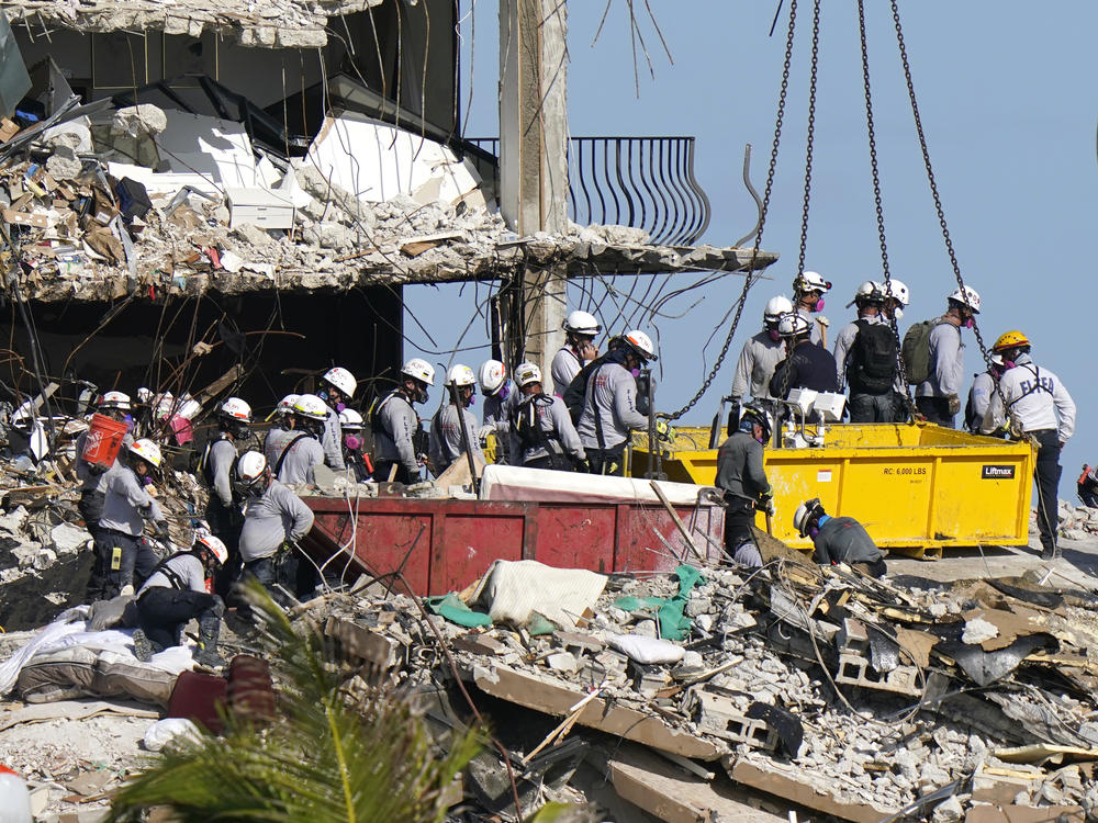 Rescue workers search for survivors in the rubble at the Champlain Towers South condo building Monday in Surfside, Fla. Some 150 people remain unaccounted for after the building partially collapsed last week.