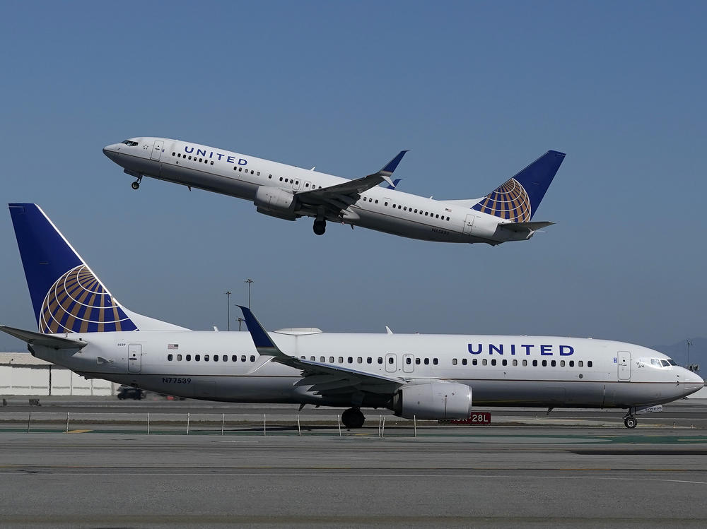 A United Airlines plane takes off over another plane on the runway at San Francisco International Airport last year. United Airlines has announced a new order of 270 narrow-bodied planes from Boeing and Airbus.