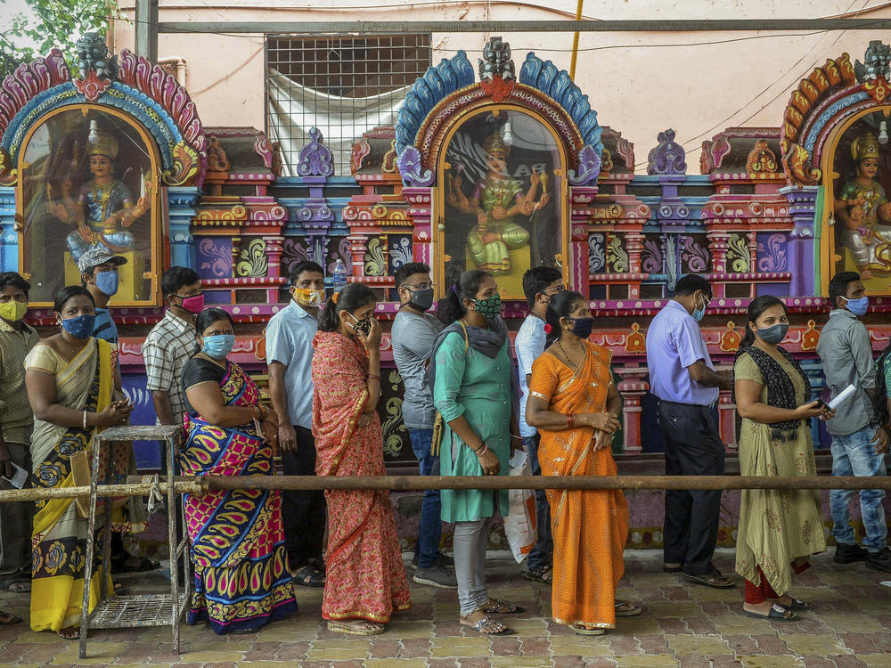 On June 25, people queued up to register for a COVID-19 vaccine at a site outside a Hindu temple in Hyderabad. Vaccinations are now being administered after a series of missteps led to a shortage of doses. If all goes well, India's public health agency hopes to be vaccinating up to 10 million people a day by late July.