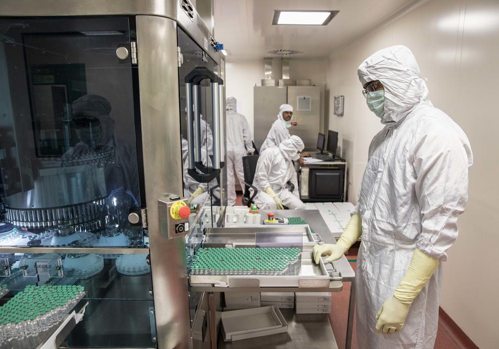 A technician at India's Serum Institute, the world's largest manufacturer of vaccines, waits to collect vials containing vaccine after they pass through a machine that checks for bottling and vaccine substance deficiencies. For a number of reasons, the supply of COVID vaccines for Indians has fallen short. So far only 4% of the population has been vaccinated.