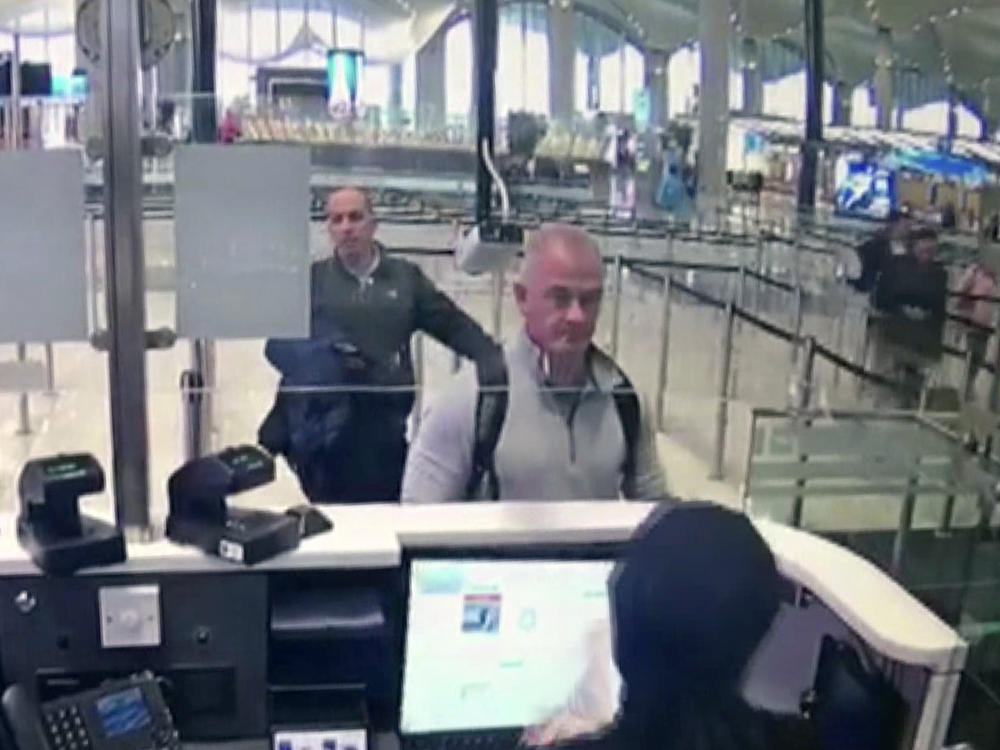 This Dec. 30, 2019 image from security camera video shows Michael L. Taylor, center, and George-Antoine Zayek at passport control at Istanbul Airport in Turkey. Taylor and his son Peter, are charged in Japan with helping Nissan's former chairman, Carlos Ghosn, jump bail and escape Japan for Lebanon.