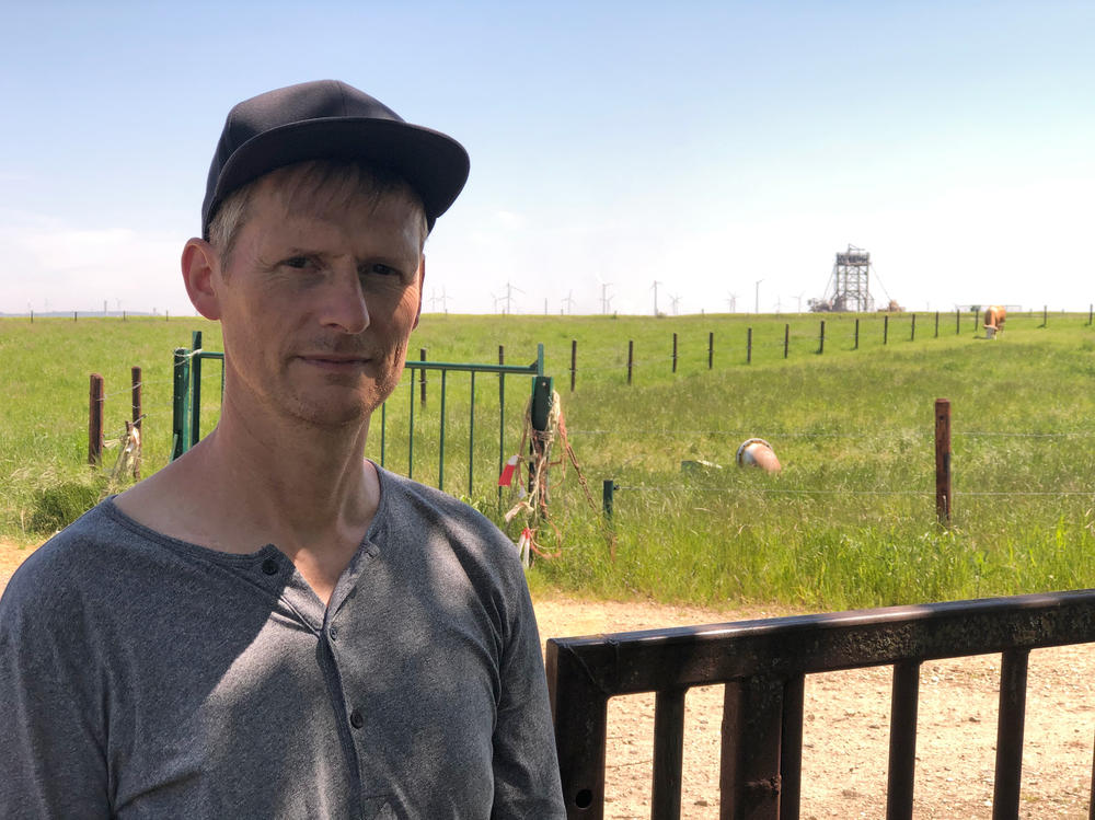 Norbert Winzen, pictured on his farm in Keyenberg as a bucket-wheel excavator operates in the distance. In April, Germany's constitutional court ruled that the government needs to do more to reduce emissions levels. Winzen is hopeful the ruling will help save his family farm and the village.