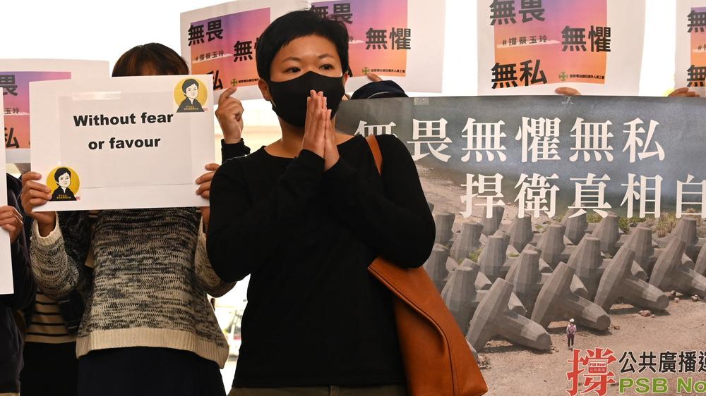 RTHK producer Bao Choy (center) stands with her supporters in Hong Kong on March 24. The TV producer was charged under the national security law after reporting on the authorities' response to a mob attack on anti-government protesters in 2019.