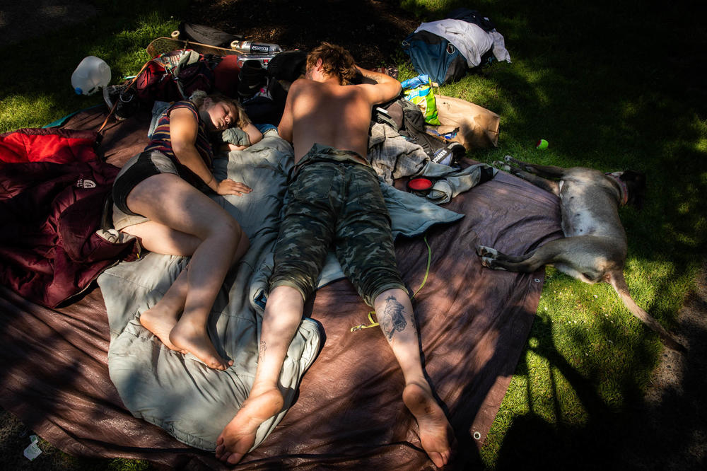 Portland recorded three of its hottest days in history last Saturday and this Sunday and Monday. Here, a couple and their dog lay in the shade during the heat wave.