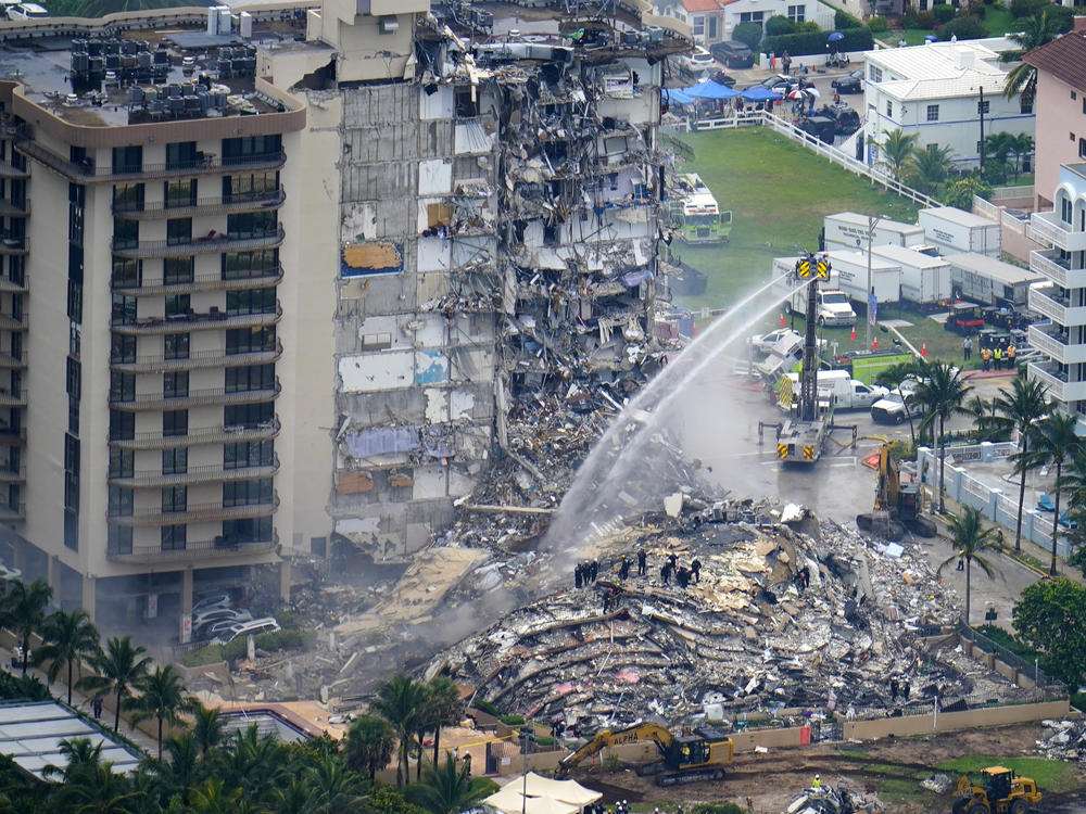 In this June 25, 2021, file photo, rescue personnel work at the remains of the Champlain Towers South condo building in Surfside, Fla.