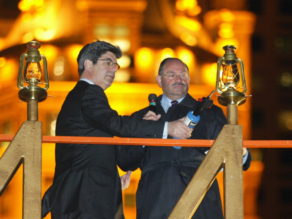 Allen Weisselberg (right), the longtime chief financial officer of the Trump Organization, lights a Hanukkah menorah with then-Macy's CEO Ron Klein in 2004 in New York City.