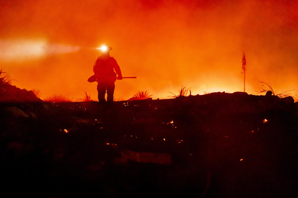 A firefighter works to protect homes in Mountain Home Village, Calif., from the El Dorado Fire, inside the San Bernardino National Forest, on Sept. 10, 2020.