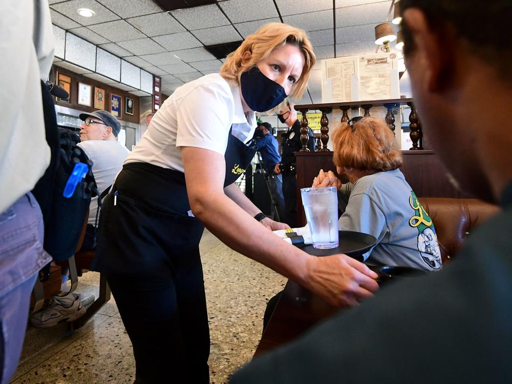 A waitress wears a face mask while serving at Langer's Delicatessen-Restaurant in Los Angeles on June 15.
