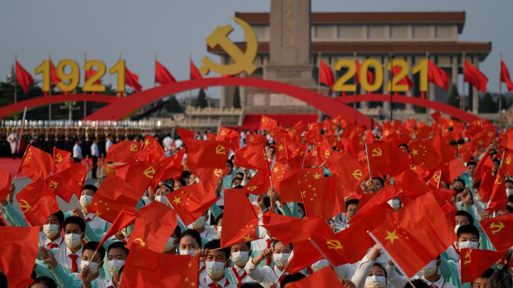 Students wave flags of China and the Chinese Communist Party before celebrations Thursday in Beijing to mark the 100th anniversary of the founding of the party.
