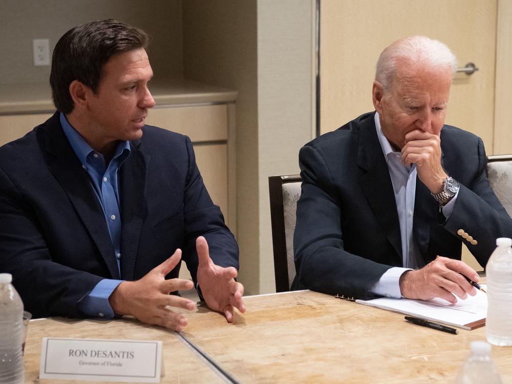 President Biden listens Thursday as Florida Gov. Ron DeSantis discusses the collapse of the 12-story Champlain Towers South condo building in Surfside, Fla.