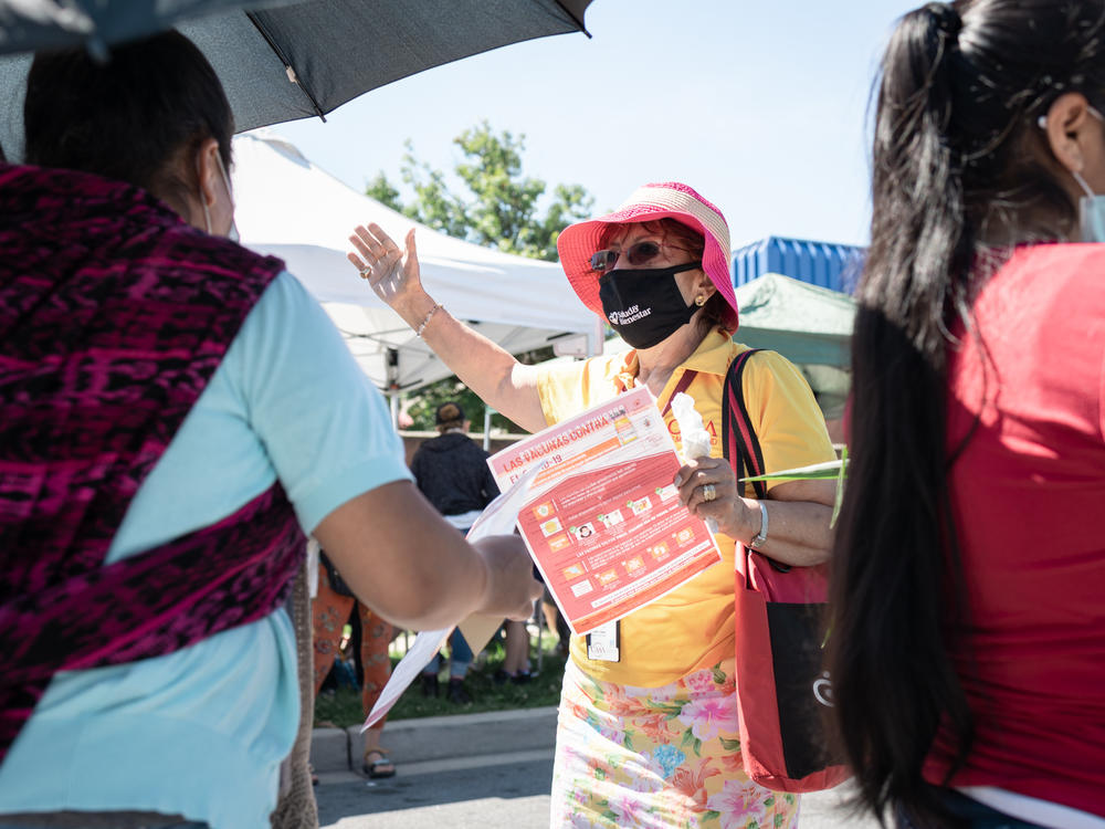 Promotora Gladis Lopez engages community members on June 23 at the Crossroads Farmers Market located at the border of Takoma Park and Langley Park, an area of suburban Maryland with a large Latino population.