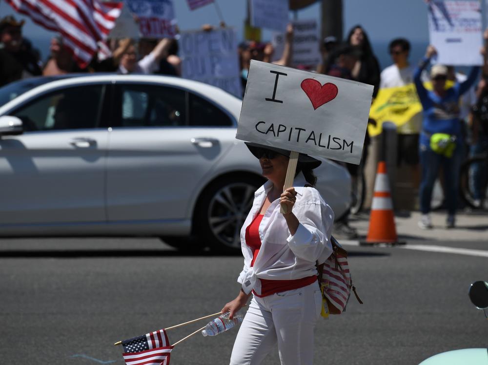A demonstrator holds a sign reading 
