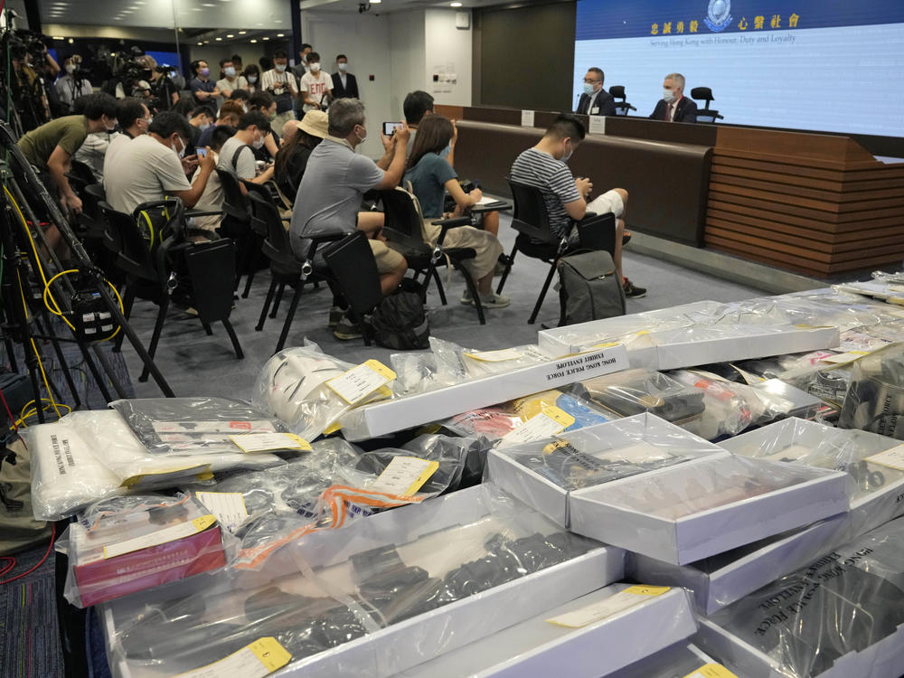 Police officials hold a news conference with confiscated evidence at police headquarters in Hong Kong on Tuesday. Police say they arrested nine people on suspicion of engaging in terrorist activity, after uncovering an attempt to make explosives and plant bombs across the city.
