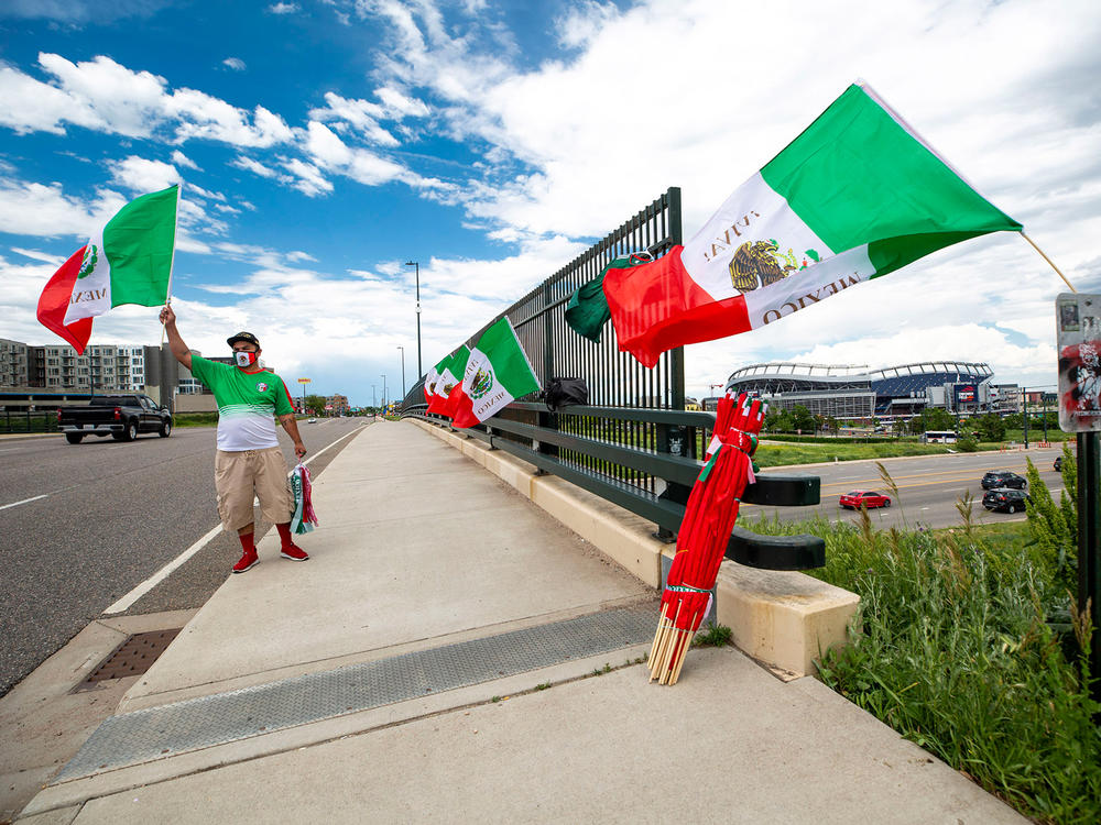 Raul Gomez sells Mexican flags Tuesday before the U.S. and Mexico national teams face off in the CONCACAF Nations League finals at Mile High Stadium.